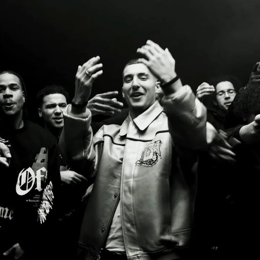 Black and white photo of a man wearing a vintage-style leather jacket in a crowd.